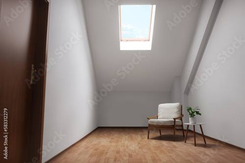 Attic spacious room interior with slanted ceiling and furniture