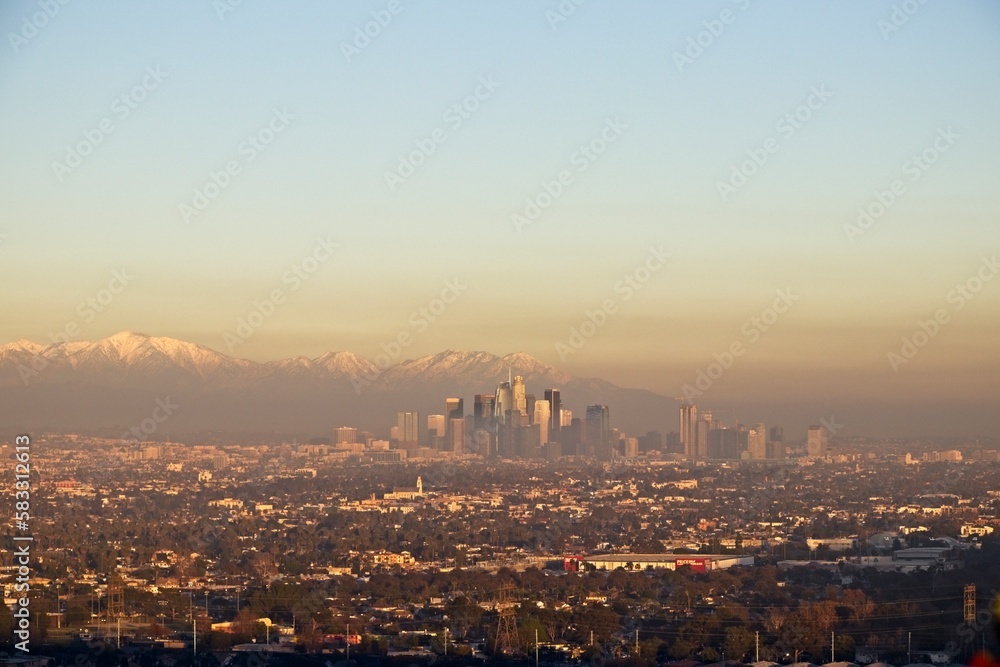 Snow tops the San Gabriel Mountains that tower above Los Angeles as evening falls on the city.