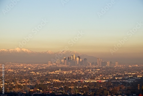 Snow tops the San Gabriel Mountains that tower above Los Angeles as evening falls on the city.