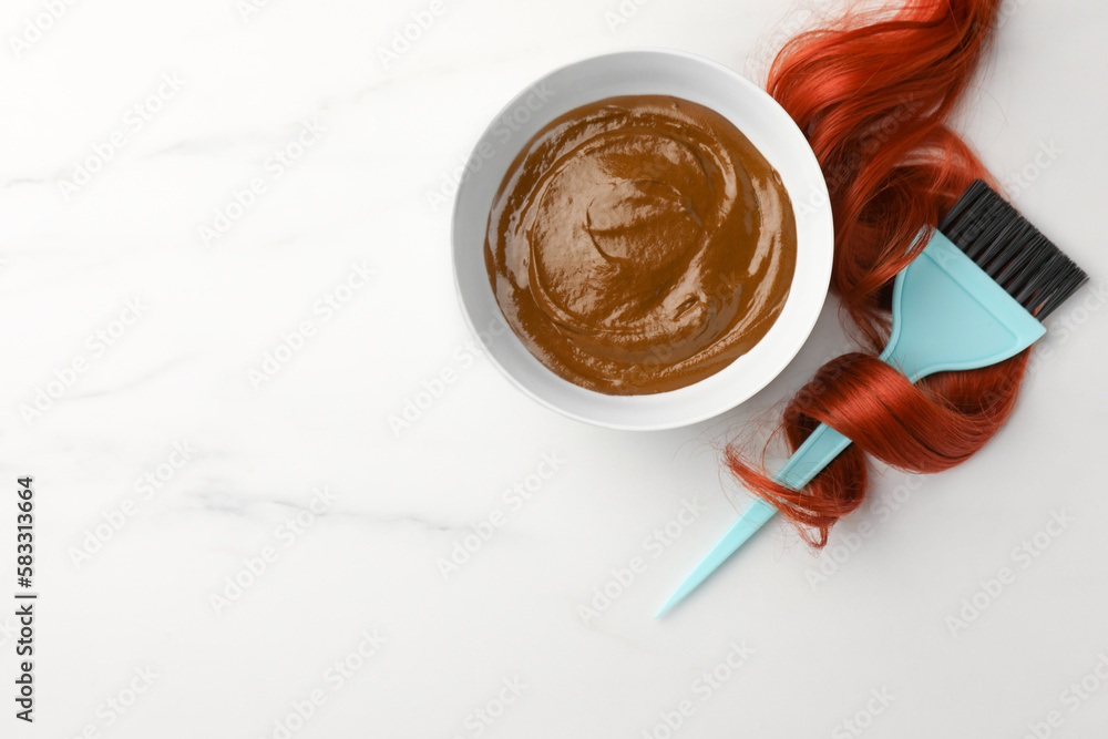 Bowl of henna cream, brush and red strand on white marble table, flat lay with space for text. Natural hair coloring Bowl of henna cream, brush and red strand on white marble table, flat lay with space for text. Natural hair coloring