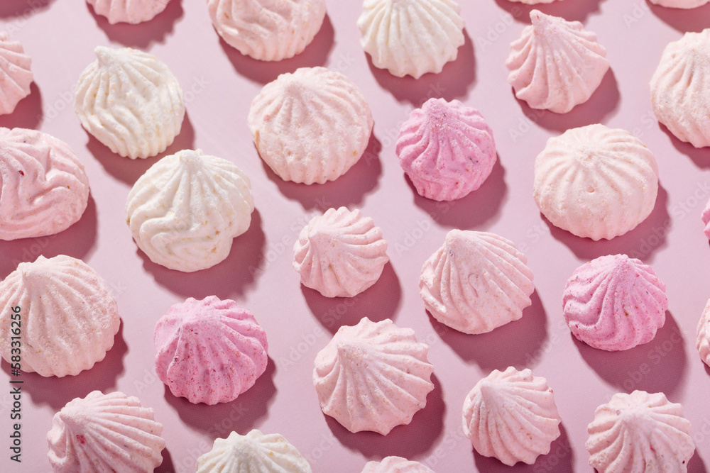 Pink meringue cookies with berry flavor on a pink background