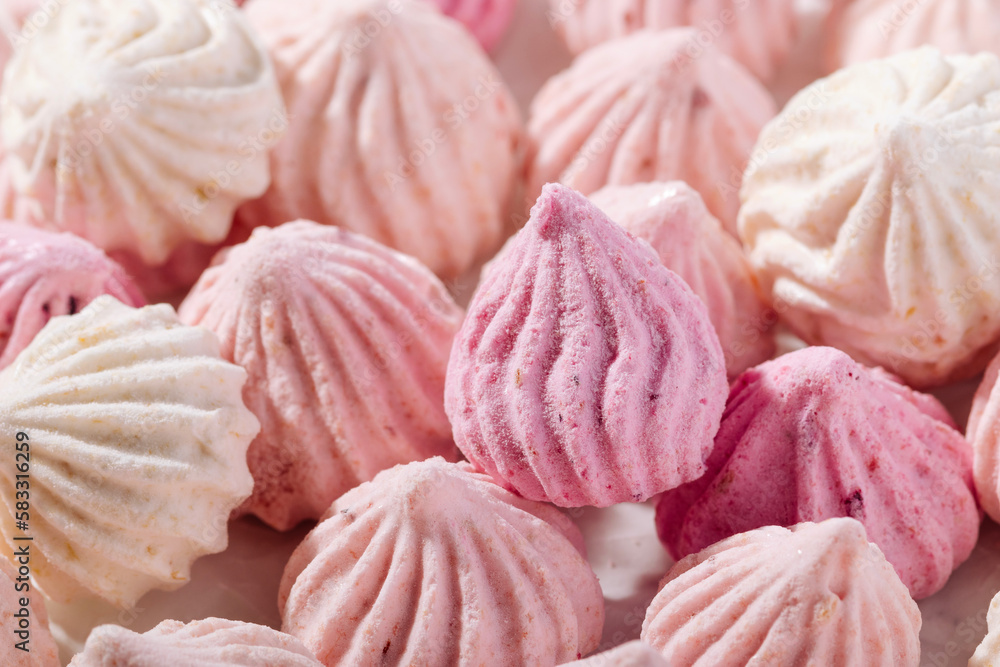 Pink meringue cookies with berry flavor on baking parchment Pink meringue cookies with berry flavor on baking parchment