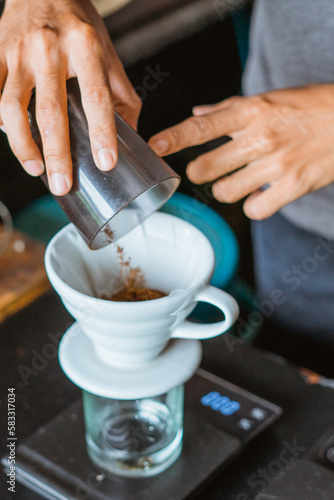 close up of hand making a coffee with filter on the glass