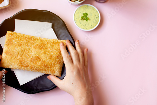 Obraz na plátně Holding a Fried Brazilian Pastel in Hand, Top View