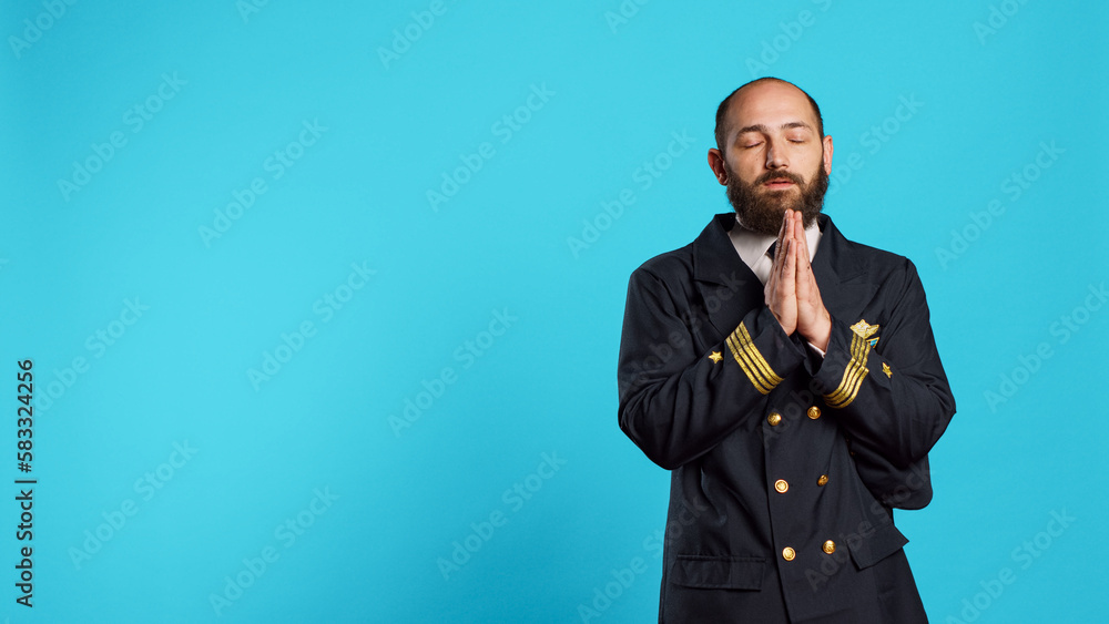 Religious young aviator praying to jesus on camera, being spiritual and worshiping god. Male airplane pilot holding hands in prayer symbol, asking for forgiveness and having faith in holy christ. Religious young aviator praying to jesus on camera, being spiritual and worshiping god. Male airplane pilot holding hands in prayer symbol, asking for forgiveness and having faith in holy christ.