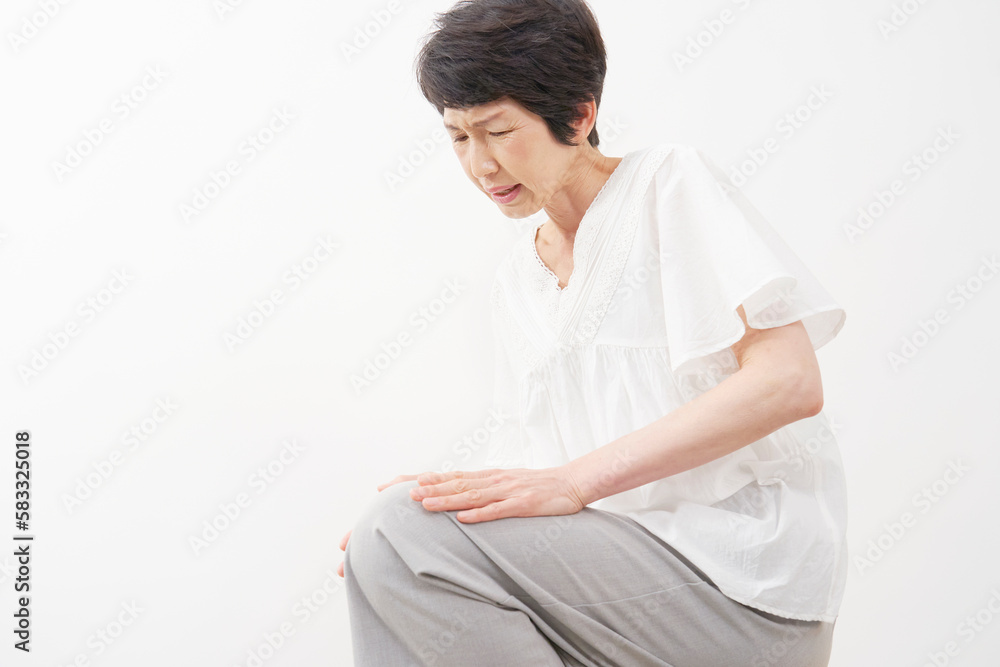 膝が痛む中年女性 白背景 膝が痛む中年女性 白背景