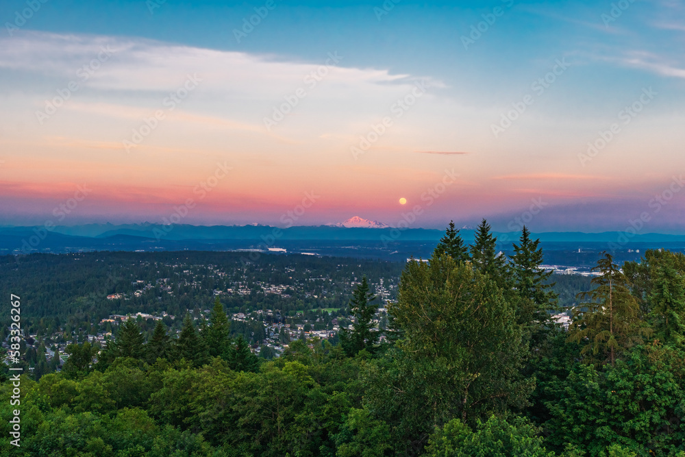 Sunset over Fraser Valley, BC, with simultaneous moonrise over Mount Baker, Washington, USA, on horizon.