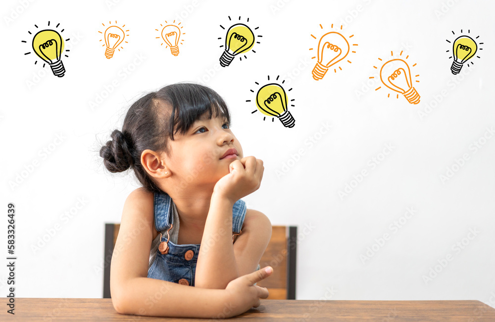 Portrait of happy smiling little child asian student girl having fun sit on table and looking at education thinking with lightbulb brainstorming creative idea.Back to school concept Portrait of happy smiling little child asian student girl having fun sit on table and looking at education thinking with lightbulb brainstorming creative idea.Back to school concept