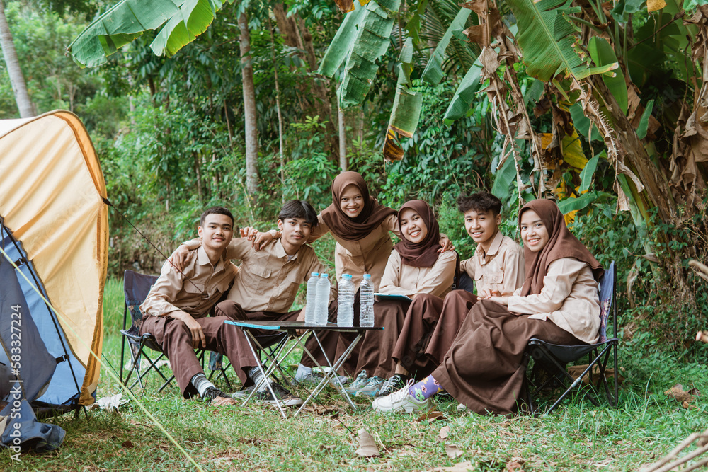 group of young scouts smiling at the camera while gathering in nature