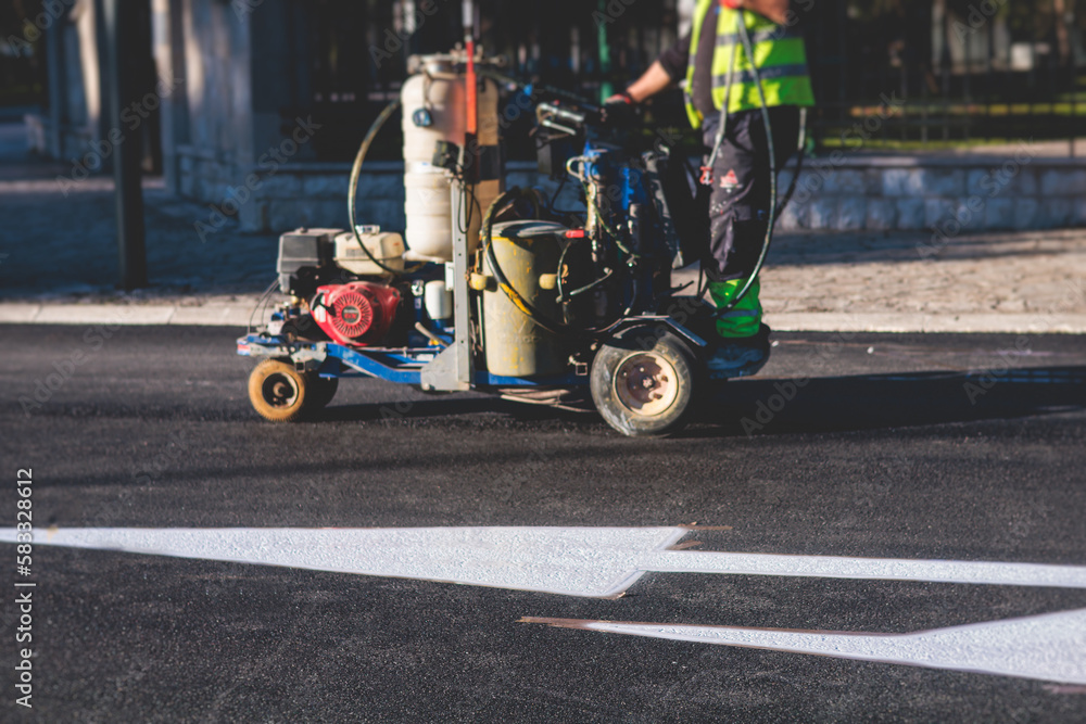 Process of making new road surface markings with a line striping machine, workers improve city infrastructure, demarcation marking of pedestrian crossing with a hot melted paint on asphalt pavement Process of making new road surface markings with a line striping machine, workers improve city infrastructure, demarcation marking of pedestrian crossing with a hot melted paint on asphalt pavement