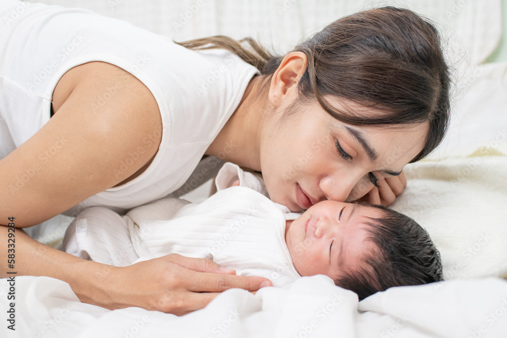 happy loving family. mother playing with her baby hugging in the bedroom , portrait of asian mother playing with newborn baby, health care family love together. asian girl lifestyle.. happy loving family. mother playing with her baby hugging in the bedroom , portrait of asian mother playing with newborn baby, health care family love together. asian girl lifestyle..