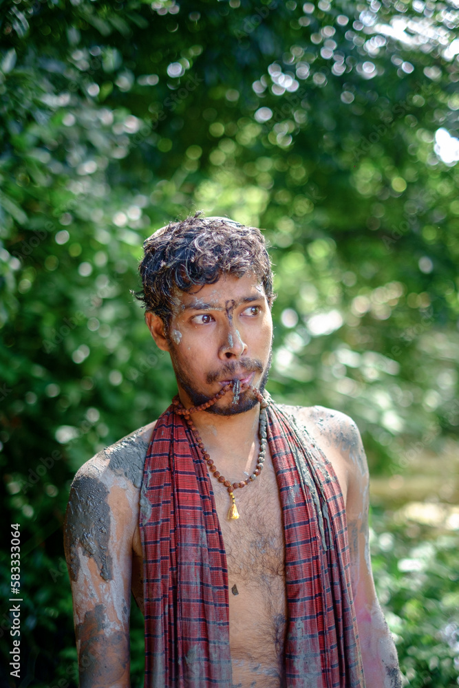 Hindu young devotee painted his body and faces with mud and colours in Durgapuja festival Hindu young devotee painted his body and faces with mud and colours in Durgapuja festival