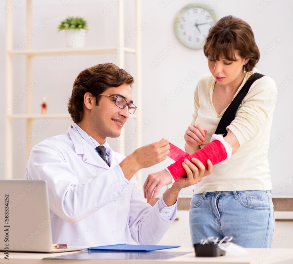 Fototapeta premium Young woman visiting doctor traumatologist