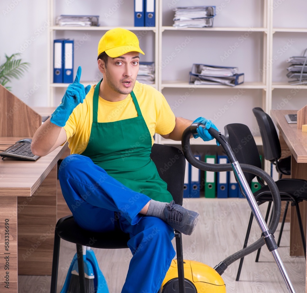 Young male contractor cleaning the office Young male contractor cleaning the office