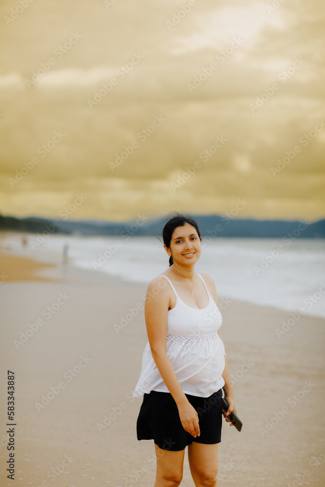 The pregnant woman smiled brightly. Sea by the beach The pregnant woman smiled brightly. Sea by the beach