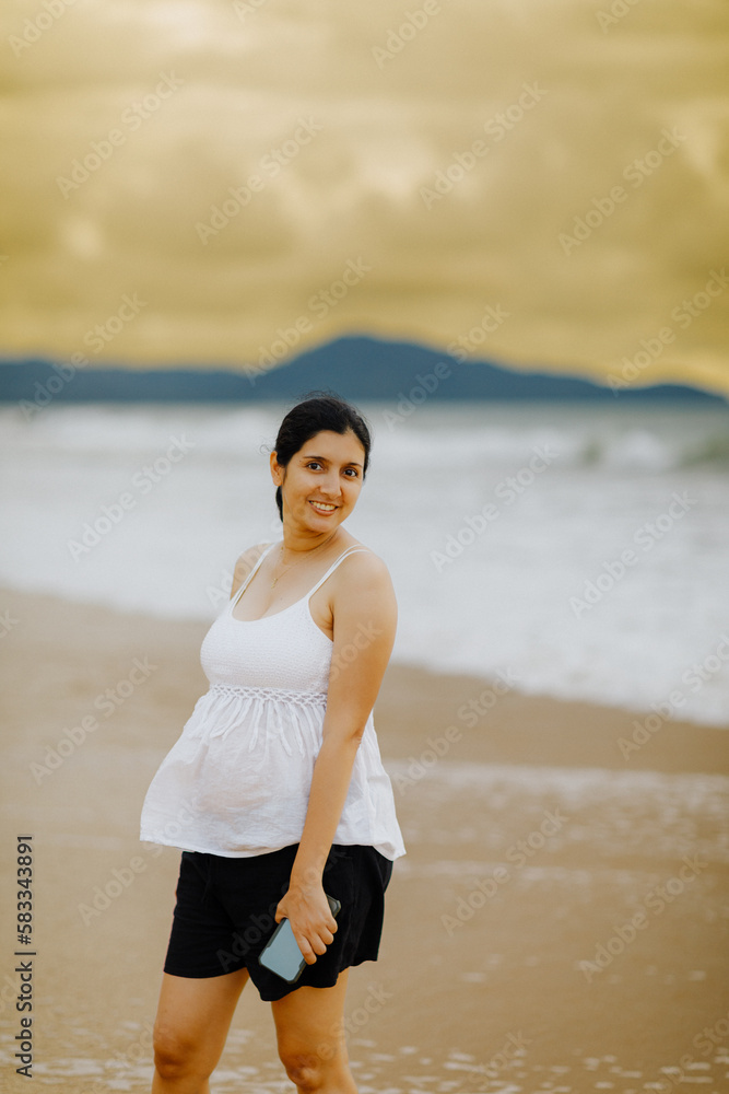 The pregnant woman smiled brightly. Sea by the beach The pregnant woman smiled brightly. Sea by the beach