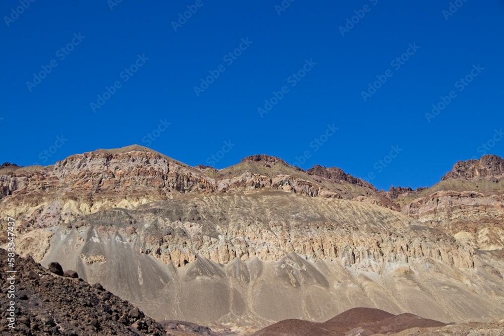Fototapeta premium Driving along Artist's Drive, a one-way scenic loop in Death Valley, reveals rocks with a surprising number of colors. It is home to Artist's Pallette, which has a dusting of green and pink colors.
