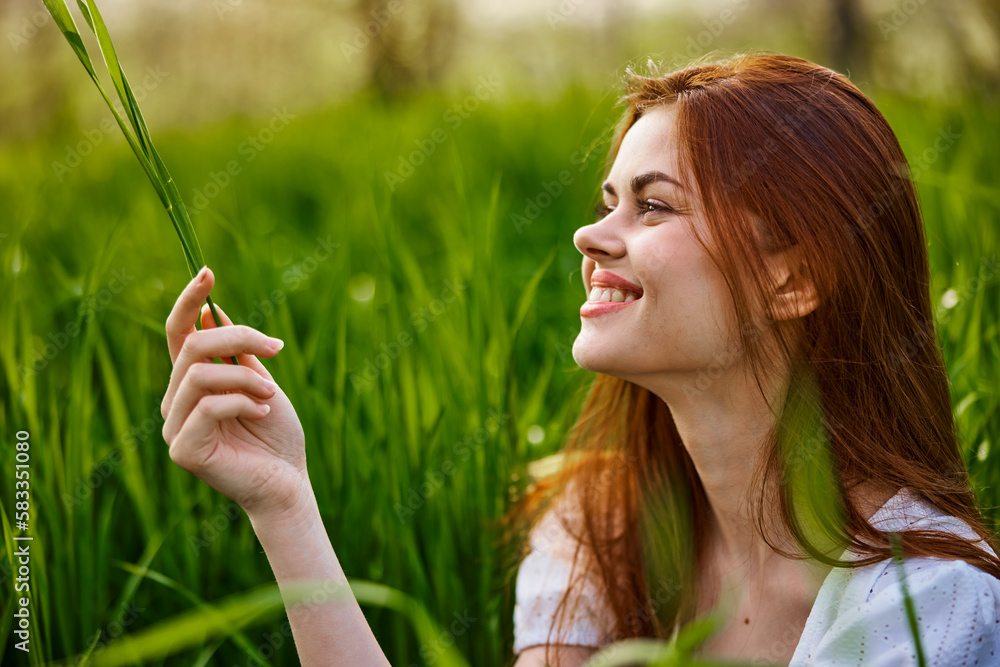 portrait of a happy, laughing woman sitting in tall grass in a field portrait of a happy, laughing woman sitting in tall grass in a field