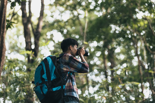Hikers with backpacks use camera shooting lanscape in the forest. hiking and adventure concept.