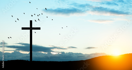 Christian cross on hill outdoors at sunrise. Resurrection of Jesus. Concept photo.