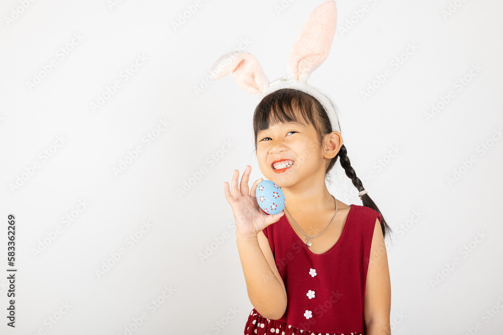 Happy Easter Day. Smile Asian little girl wearing easter bunny ears holding colorfull eggs on hands isolated on white background with copy space, Happy child in holiday Happy Easter Day. Smile Asian little girl wearing easter bunny ears holding colorfull eggs on hands isolated on white background with copy space, Happy child in holiday