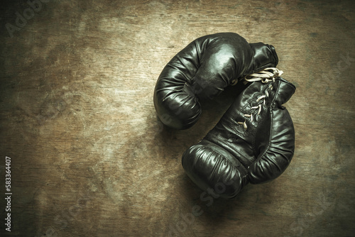 Antique boxing gloves on a wooden table.The history of a boxer. Gloves for combat. © Svetliy
