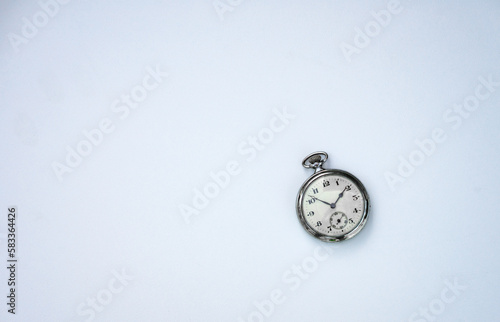 Pocket mechanical watch on white isolate. Stopwatch on a white background. A clockwork clock made of silver with Arabic numerals.