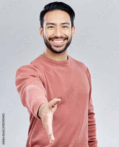 Asian man, portrait smile and handshake for meeting, deal or introduction isolated against white studio background. Happy male smiling and shaking hands for greeting, introduction or friendly gesture
