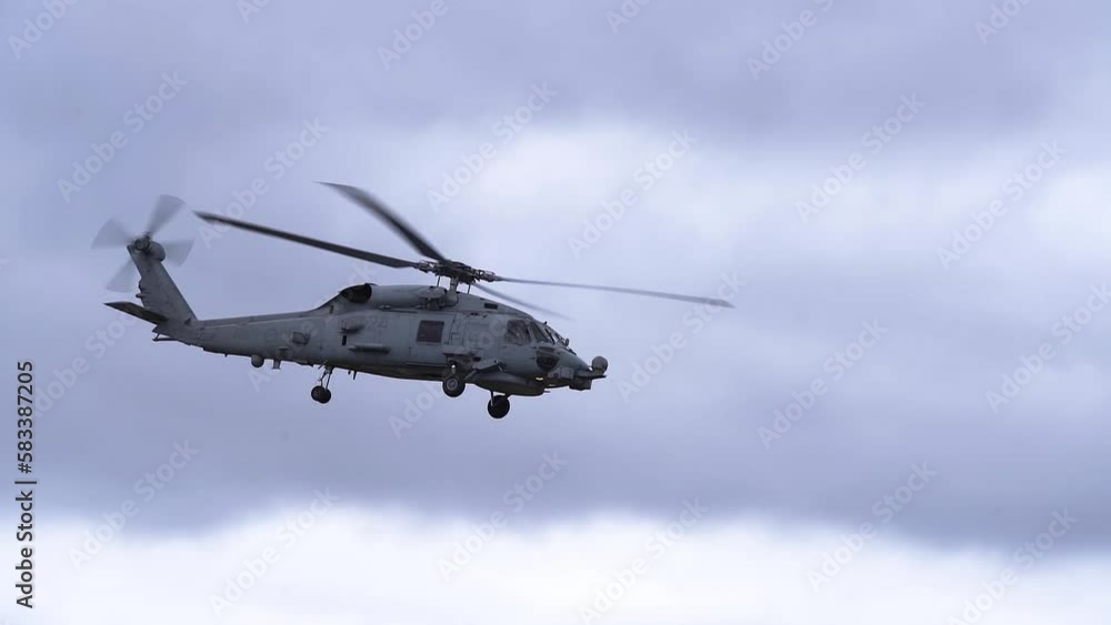 MH-60R Seahawk Helicopter Flying In Cloudy Sky - low angle MH-60R Seahawk Helicopter Flying In Cloudy Sky - low angle