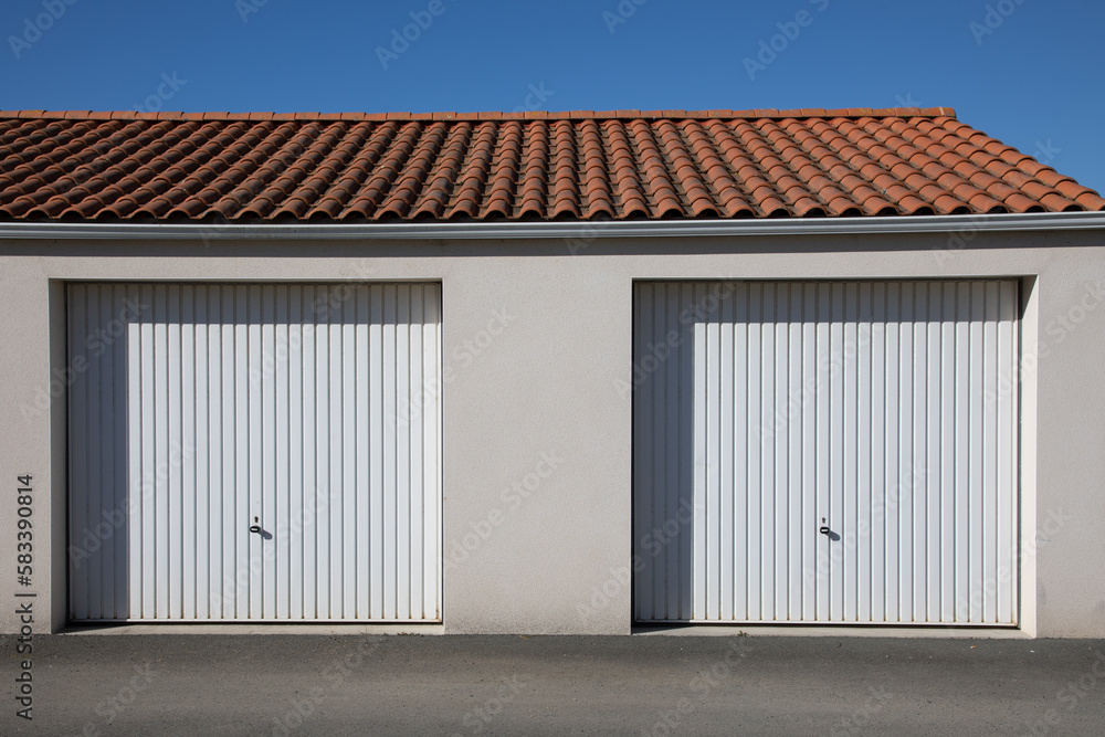 Garage double sectional two door white car entrance on facade private house
