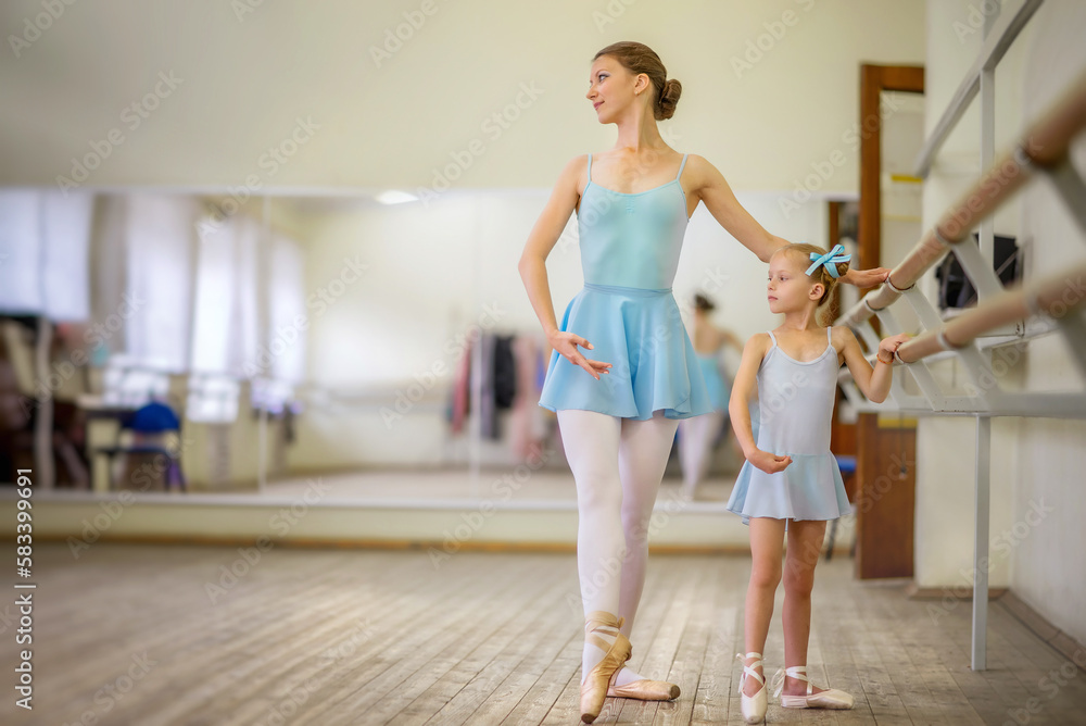 Little ballerina. Choreographer and student. Ballerinas. Girl and ballet teacher. The girl is learning to dance. Ballerinas on pointe. Ballerinas in tutus. Ballet and dance training. Dancers. Pointe