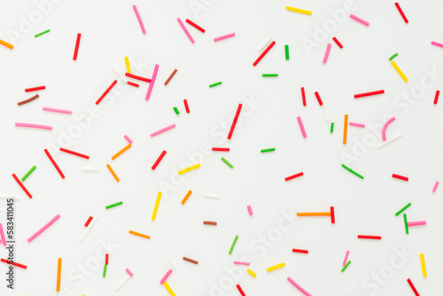 flat lay of colorful sprinkles over white background  festive decoration for banner  poster  flyer  card  postcard  cover  brochure  designers