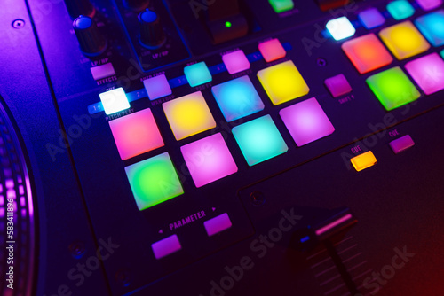 Fototapeta Naklejka Na Ścianę i Meble -  Close up of DJ mixing console in party light