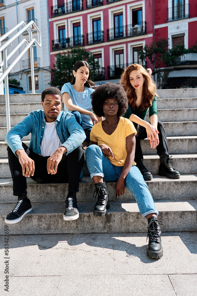 Fototapeta premium Multicultural group of friends sitting on urban stairs