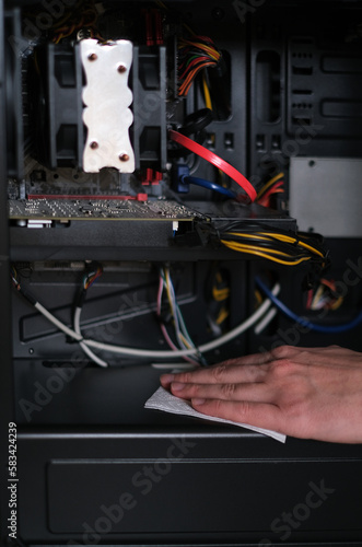 repairman cleans the computer system unit from dust close-up