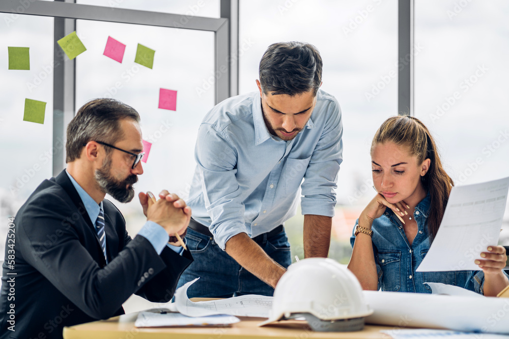 Obraz premium Professional of team architect industrial engineer cargo foreman working new construction project architectural plan with blueprint and construction tool on table at the building construction site