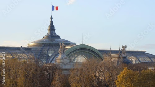 Roof of the Grand Palais with a French flag waving in the air in Paris, France in Autumn