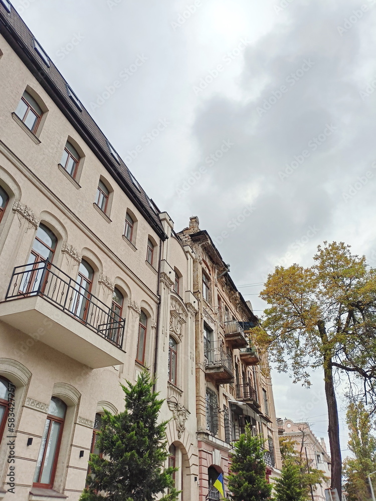 Fototapeta premium I looked down at the impeccably clean restored facade of a medieval building on Odesa Street against the background of a cloudy autumn sky.
