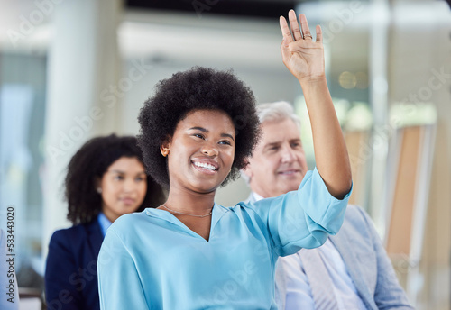Black woman, presentation and question in business, answer or FAQ in team meeting from audience in seminar. African female with hands raised in staff training, planning or strategy in crowd workshop