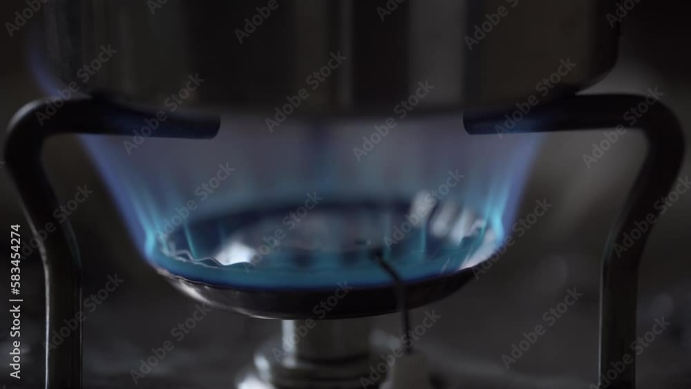 Kitchen gas stove fire inflaming, closeup burning burner flame. Ignite