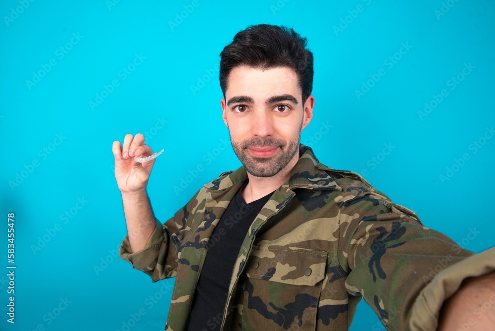 MODEL make selfie holding an invisible braces aligner, recommending this new treatment. Dental healthcare concept. MODEL make selfie holding an invisible braces aligner, recommending this new treatment. Dental healthcare concept.