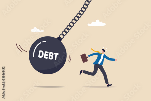 Debt problem, obligation or financial loan crisis, liability or credit failure, no money to pay for debt, mortgage default concept, business man run away from heavy wrecking ball with the word debt.