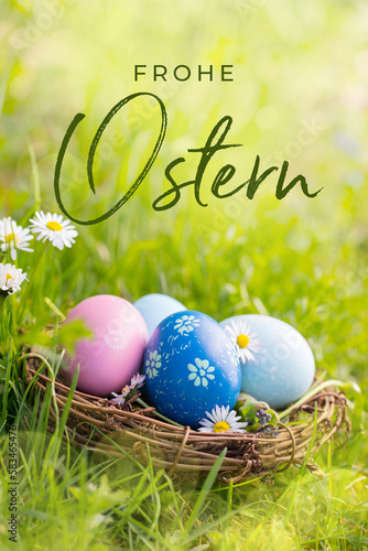 Happy Easter Card  - German text. Nest with Easter eggs in grass on a sunny spring day - Easter decoration, background  -  Copy space
