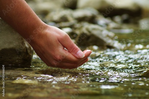 Beautiful woman hands in a river with drinking water quality