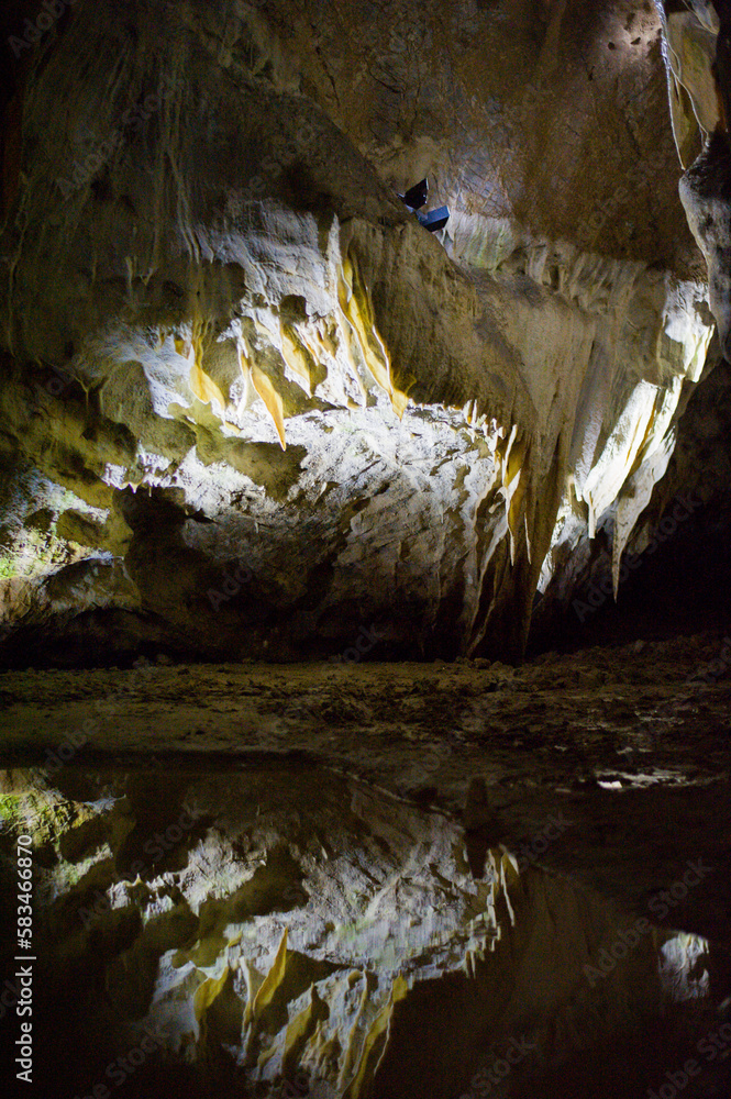 reflection of the stalactites on a still surface of the underground lake in the Macocha cave