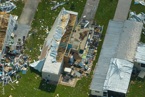 Severely damaged by hurricane Ian houses in Florida mobile home residential area. Consequences of natural disaster photo