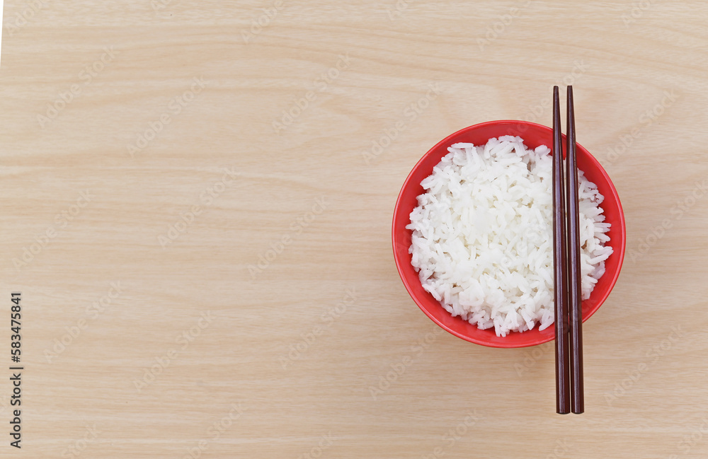 Boiled rice in red ceramic bowl chopsticks and on wood background. Asian food. Top view. Boiled rice in red ceramic bowl chopsticks and on wood background. Asian food. Top view.