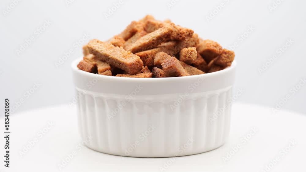 Crispy toasted bread croutons. A pile of hard rusks from dark dry bread close up. Snack for beer. Rye crackers. Snacks rye crackers in a strip. Crouton or brown roasted tostes rotating. Crispy toasted bread croutons. A pile of hard rusks from dark dry bread close up. Snack for beer. Rye crackers. Snacks rye crackers in a strip. Crouton or brown roasted tostes rotating.