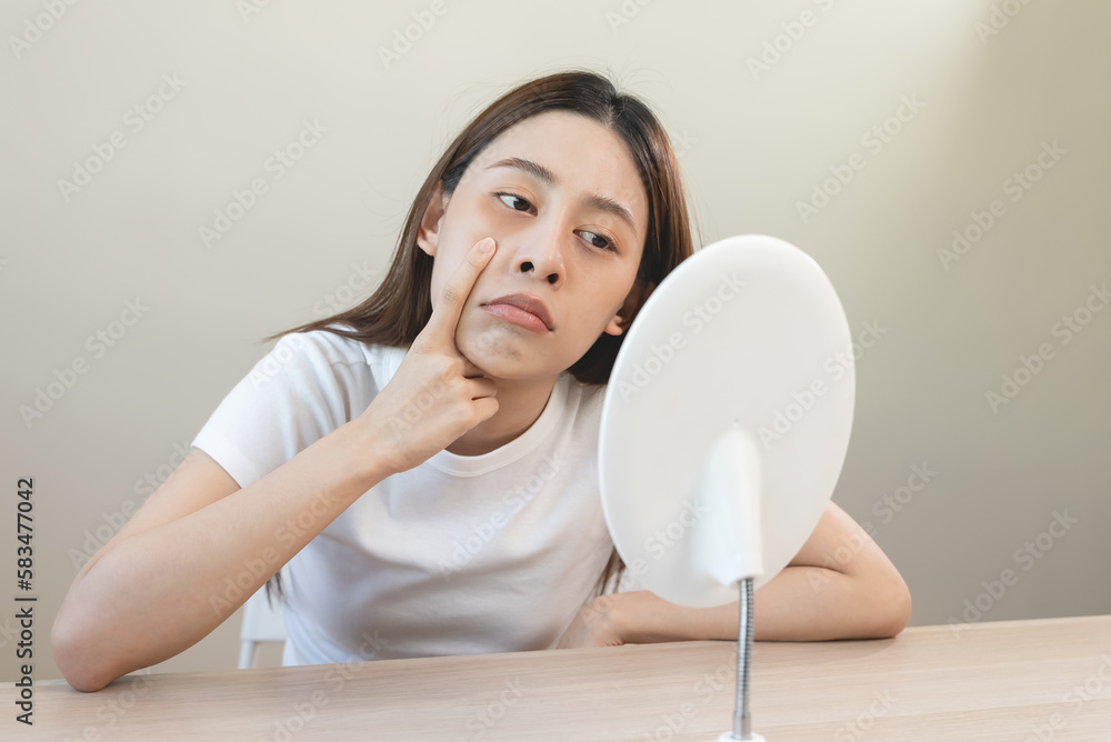 Sleepless Asian woman looking her face in the mirror and worry about dark circles under eyes Sleepless Asian woman looking her face in the mirror and worry about dark circles under eyes