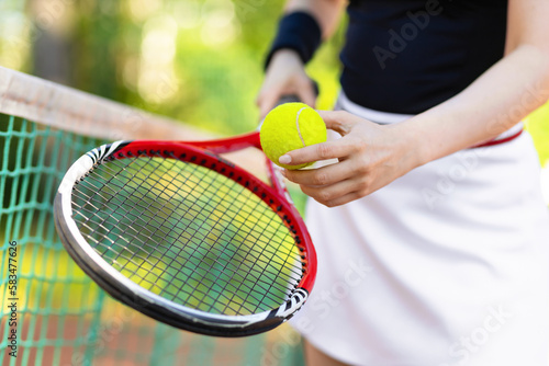 hand of female player with racket, ball near net on the tennis court outdoor. healthy sport active lifestyle. © Елена Якимова